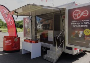 A background image showing a Virgin Media advertisement trailer from TCM Trailers